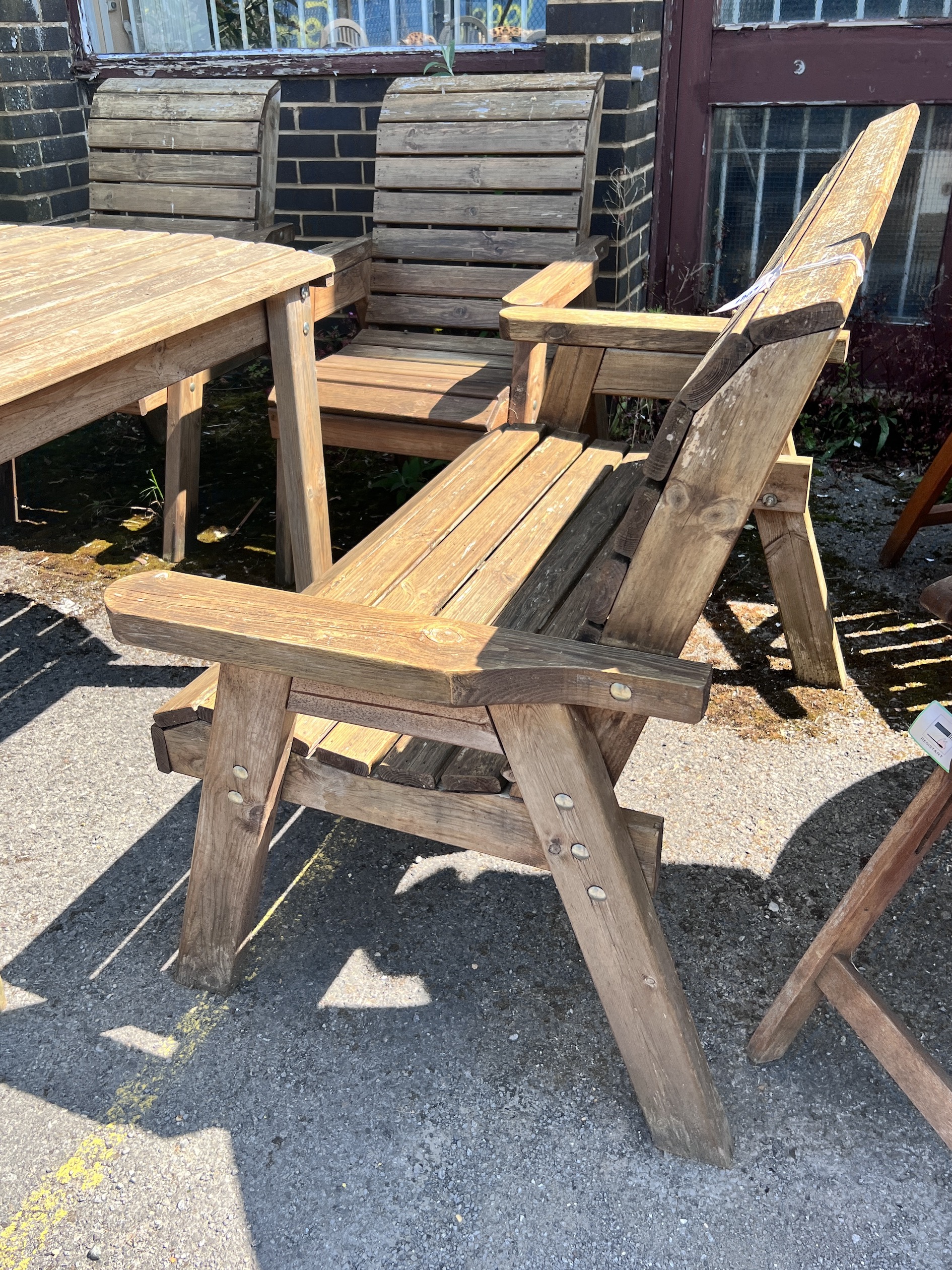 A rectangular slatted teak garden table, length 130cm, width 96cm, height 79cm, together with a pair of armchairs and a pair of benches